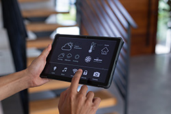 Person using tablet to control smart home technologies