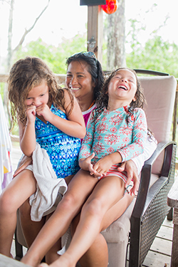 Woman sitting in chair with kids in bathing suits in summer in Lavallette
